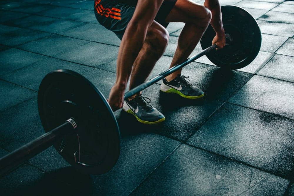 Lifter setting up a deadlift on a dark gym floor