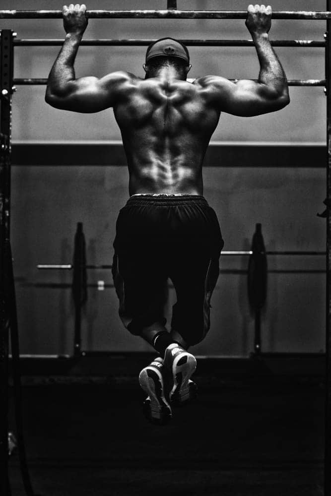 Athlete grinding out strict pull-ups on the rig
