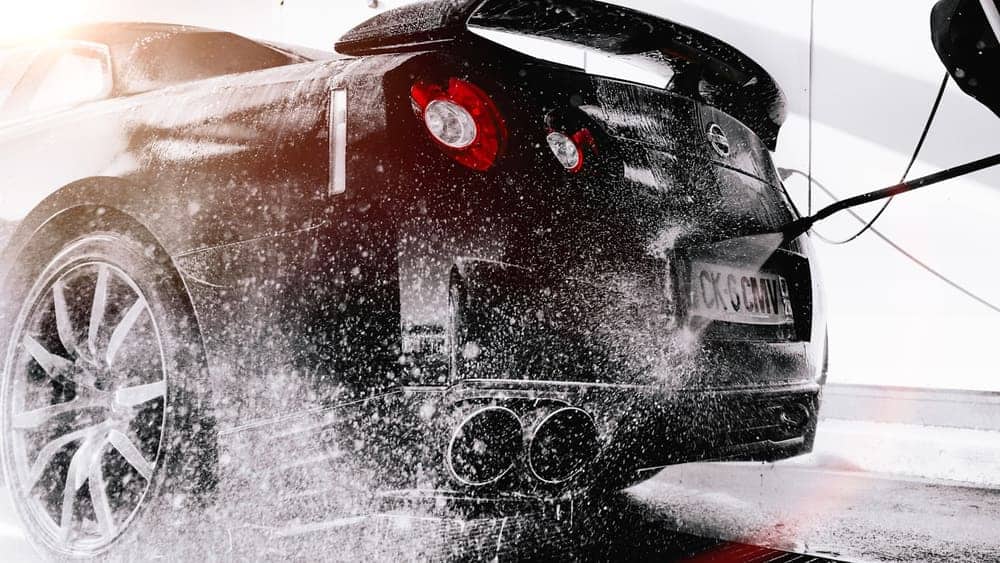 Foam wash clinging to a black sports car