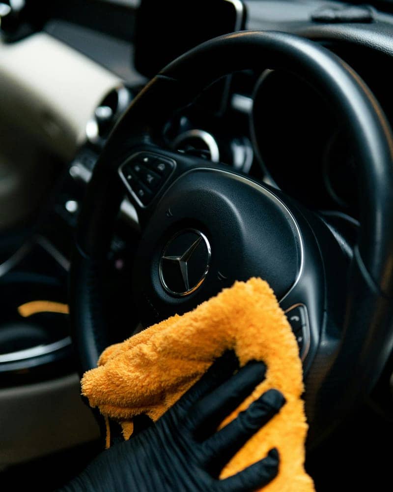 Steering wheel being wiped down with a microfiber cloth