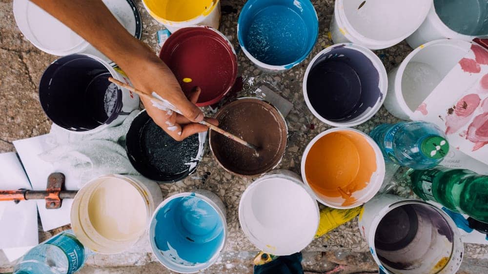 Open paint cans being mixed for a color match