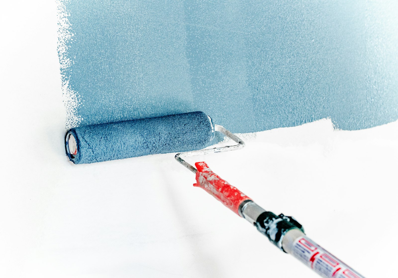 Painter rolling fresh paint onto a residential wall