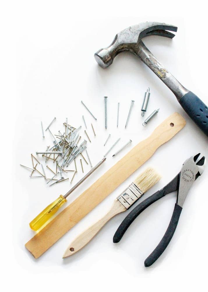 Hammer, nails, and brush laid out for a repair
